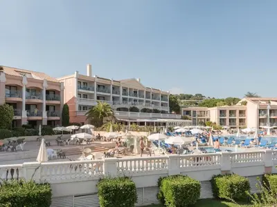 a view of a resort with a pool and tables and umbrellas at Stunning condo with SEA VIEW Balcony & SWIMMING POOL in Cannes
