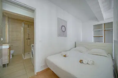 a white bedroom with a white bed and a bathroom at Studio Moderne BALCON, proche FORVILLE- CENTRE CANNES A0B198 in Cannes
