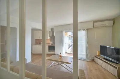 a living room with a table and a television at Studio Moderne BALCON, proche FORVILLE- CENTRE CANNES A0B198 in Cannes