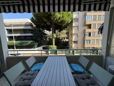 a blue table and chairs on a balcony with a building at 2P proche mer sib06 in Cannes