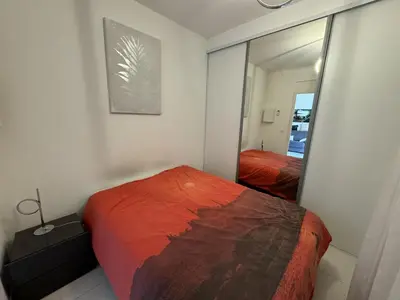 a bedroom with a bed and a mirror at 2P proche mer sib06 in Cannes