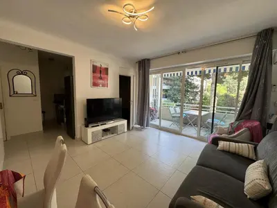 a living room with a couch and a television at 2P proche mer sib06 in Cannes