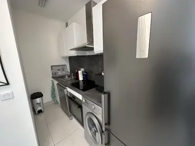 a kitchen with a stainless steel refrigerator and a washer at 2P proche mer sib06 in Cannes