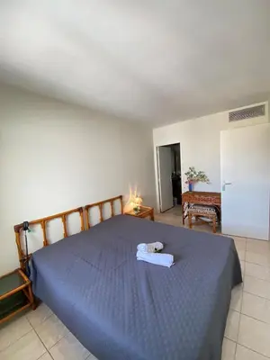 a bedroom with a bed with a blue comforter at Belle terrasse apercu mer NAF568 in Cannes