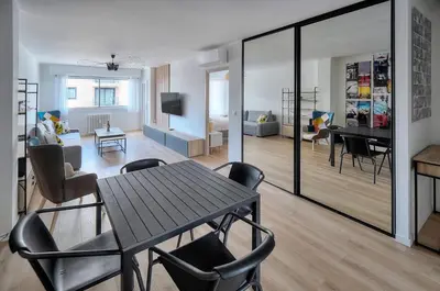 a room with a table and chairs and a living room at Moderne 2 chambres TERRASSE, MARTINEZ CARLTON A2B249 in Cannes