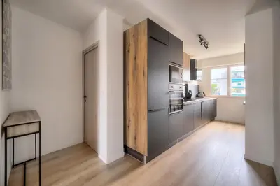 a kitchen with gray cabinets and a wooden floor at Moderne 2 chambres TERRASSE, MARTINEZ CARLTON A2B249 in Cannes