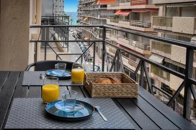 a table with a basket of bread and glasses of orange juice at Moderne 2 chambres TERRASSE, MARTINEZ CARLTON A2B249 in Cannes