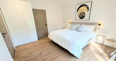 a white bedroom with a large bed with white sheets at Ref VCLAIR by Palmes dProperties in Cannes