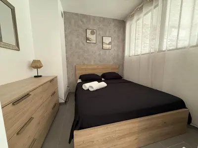 a bedroom with a bed with black sheets and white towels at SINT Cannes T 1 in Cannes
