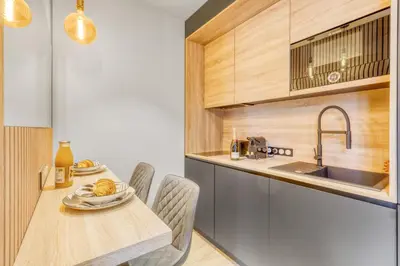 a kitchen with a table and chairs and a sink at Studio W - Ascenseur - 2 min du Palais - Climatisé in Cannes