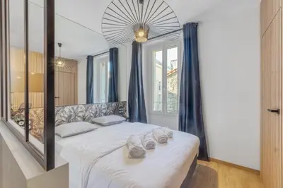 a bedroom with a bed with shoes on it at Studio W - Ascenseur - 2 min du Palais - Climatisé in Cannes