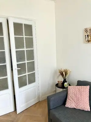 a living room with a couch and a door at Cannes Centre Apartment 2-Room by Palais des Festivals & Beach in Cannes