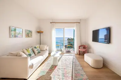 a living room with a couch and a view of the ocean at 49 CLEM - Superbe appartement 2 chambres 4 pers avec vue mer in Cannes