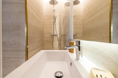 a bathroom with a white sink and a shower at 49 CLEM - Superbe appartement 2 chambres 4 pers avec vue mer in Cannes