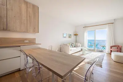 a kitchen and living room with a table and chairs at 49 CLEM - Superbe appartement 2 chambres 4 pers avec vue mer in Cannes