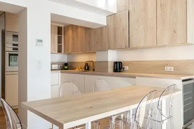 a kitchen with a wooden table and chairs at 49 CLEM - Superbe appartement 2 chambres 4 pers avec vue mer in Cannes
