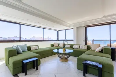 a large living room with green couches and a table at Rare Penthouse - Vue panoramique in Cannes