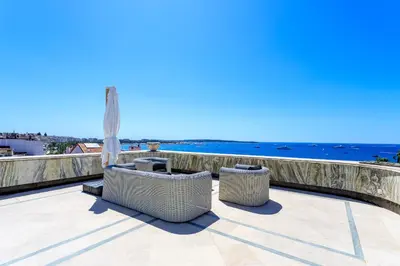 a patio with a hammock and a view of the ocean at Rare Penthouse - Vue panoramique in Cannes