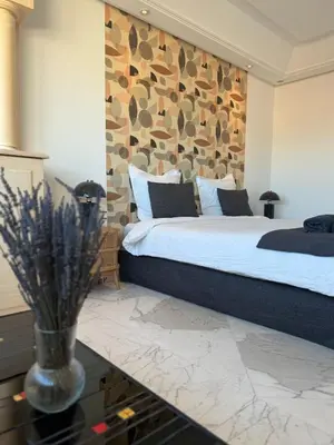 a bedroom with a large bed with a stone wall at Rare Penthouse - Vue panoramique in Cannes