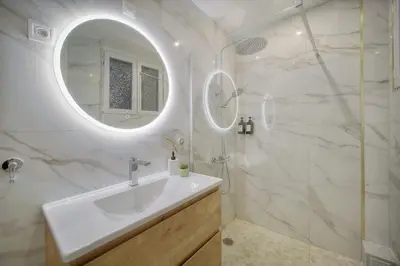 a white bathroom with a sink and a mirror at Seabatical Apartment by the beach, 2Bed and 2Baths in Cannes