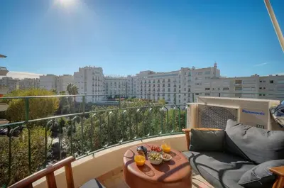 a balcony with a couch and a table with drinks on it at Seabatical Apartment by the beach, 2Bed and 2Baths in Cannes