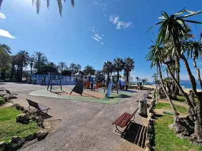 a park with benches and a playground with palm trees at Seabatical Apartment by the beach, 2Bed and 2Baths in Cannes