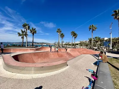 a skate park with a skateboard ramp and a child riding a scooter at Seabatical Apartment by the beach, 2Bed and 2Baths in Cannes