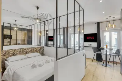 a bedroom with a large white bed and a table at Studio E - Ascenseur -2 min du Palais - Climatisé in Cannes