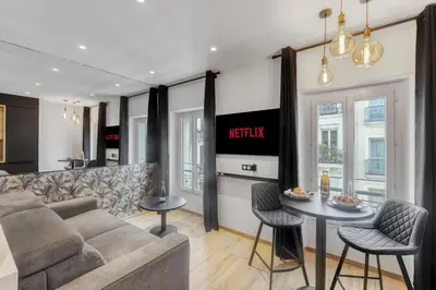 a living room with a couch and a table at Studio E - Ascenseur -2 min du Palais - Climatisé in Cannes