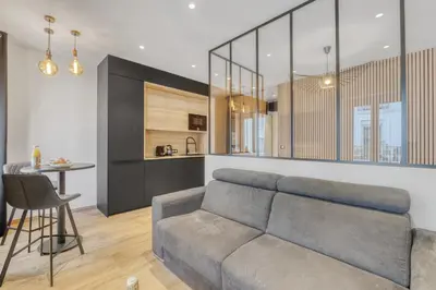 a living room with a couch and a table at Studio E - Ascenseur -2 min du Palais - Climatisé in Cannes