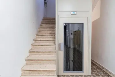 a hallway with a white door and a wooden banister at Studio E - Ascenseur -2 min du Palais - Climatisé in Cannes