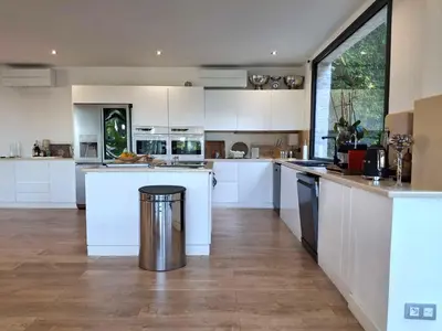 a kitchen with white cabinets and a trash can at Villa Caribbean in Cannes