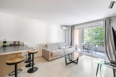 a living room with a couch and a table at Magnificent apartment with parking - AC-balcony in Cannes