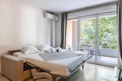 a bedroom with a bed and a balcony at Magnificent apartment with parking - AC-balcony in Cannes