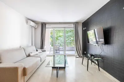 a living room with a couch and a tv at Magnificent apartment with parking - AC-balcony in Cannes
