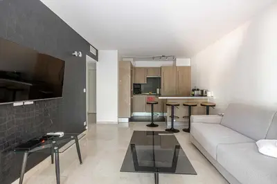 a living room with a couch and a table at Magnificent apartment with parking - AC-balcony in Cannes