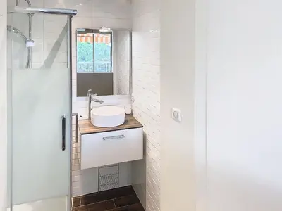 a bathroom with a sink and a glass shower door at Superbe appartement terrasse vue mer 347L GLEN in Cannes