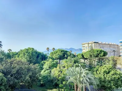 a view of a park with trees and a building at Superbe appartement terrasse vue mer 347L GLEN in Cannes