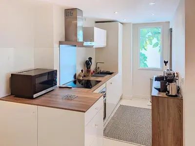 a kitchen with white cabinets and a microwave at Superbe appartement terrasse vue mer 347L GLEN in Cannes
