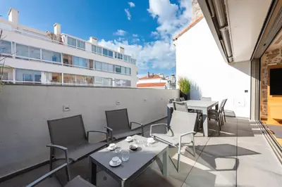 a balcony with tables and chairs and a building at DUPLEX 145m Private Terrace and Elevator in Cannes