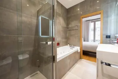 a bathroom with a shower and a tub and a sink at DUPLEX 145m Private Terrace and Elevator in Cannes