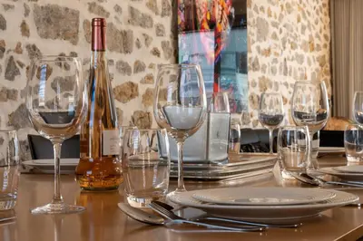 a table with wine glasses and a bottle of wine at DUPLEX 145m Private Terrace and Elevator in Cannes