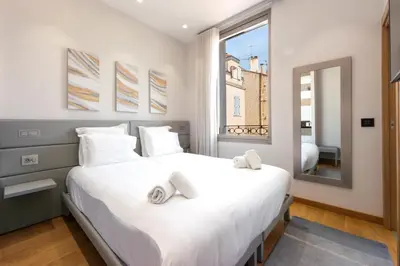 a bedroom with a large white bed with towels on it at DUPLEX 145m Private Terrace and Elevator in Cannes