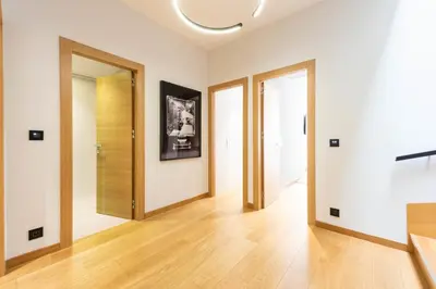 an empty room with wooden doors and wooden floors at DUPLEX 145m Private Terrace and Elevator in Cannes