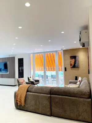 a living room with a large brown couch and chairs at Appartement 4 pièces luxueux in Cannes