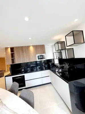 a kitchen with black and white appliances and a table at Appartement 4 pièces luxueux in Cannes
