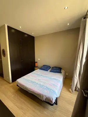 a bedroom with a bed with blue pillows on it at dans le quartier historique du suquet idéal congres et vacances in Cannes