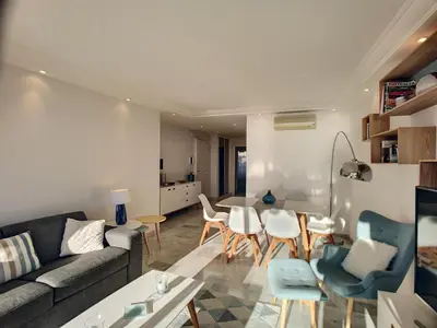 a living room with a couch and a table and chairs at Superbe vue mer terrasse - 218L MISS in Cannes