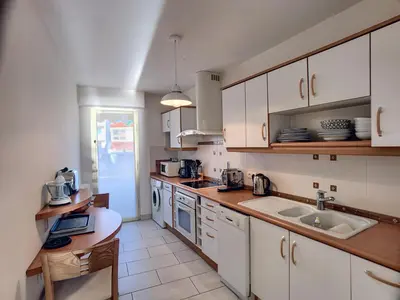 a kitchen with white cabinets and a sink at Superbe vue mer terrasse - 218L MISS in Cannes