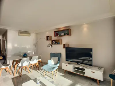 a living room with a television and a table and chairs at Superbe vue mer terrasse - 218L MISS in Cannes